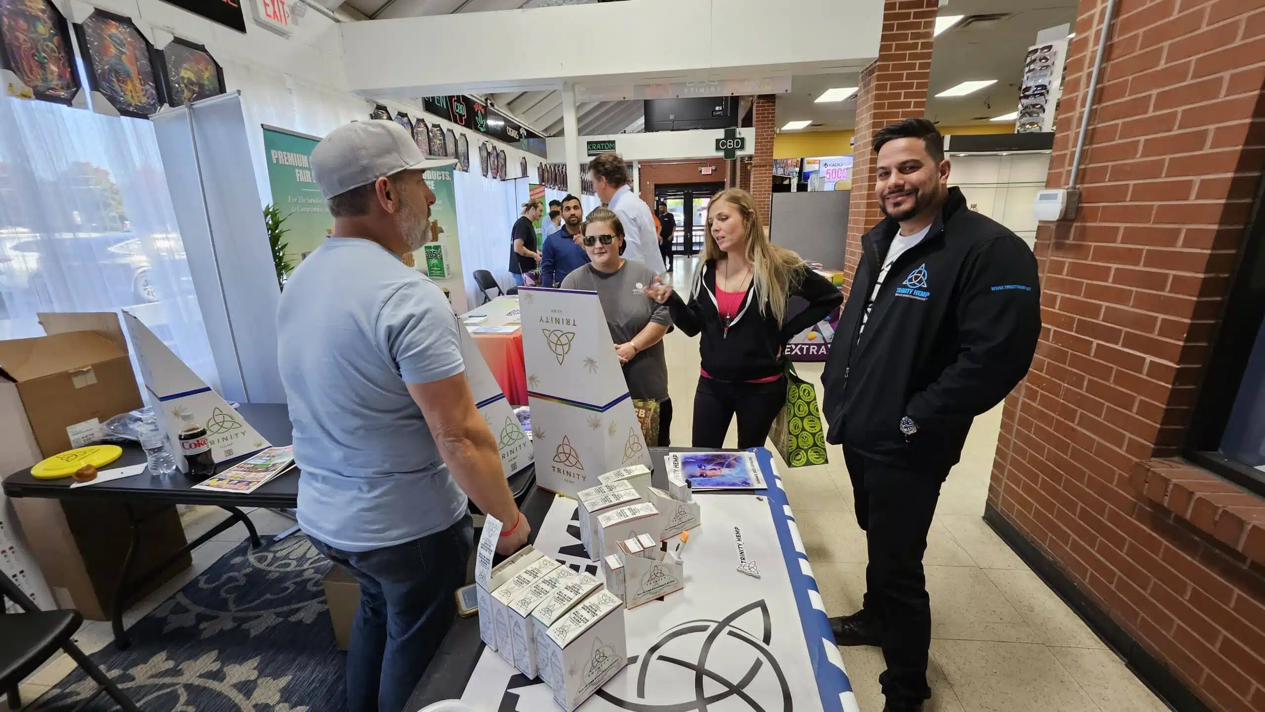 Retailers talking with a hemp brand team at a trade show booth